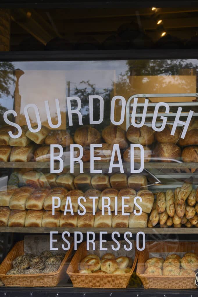 Bakery window display with sourdough bread, pastries, and espresso sign.