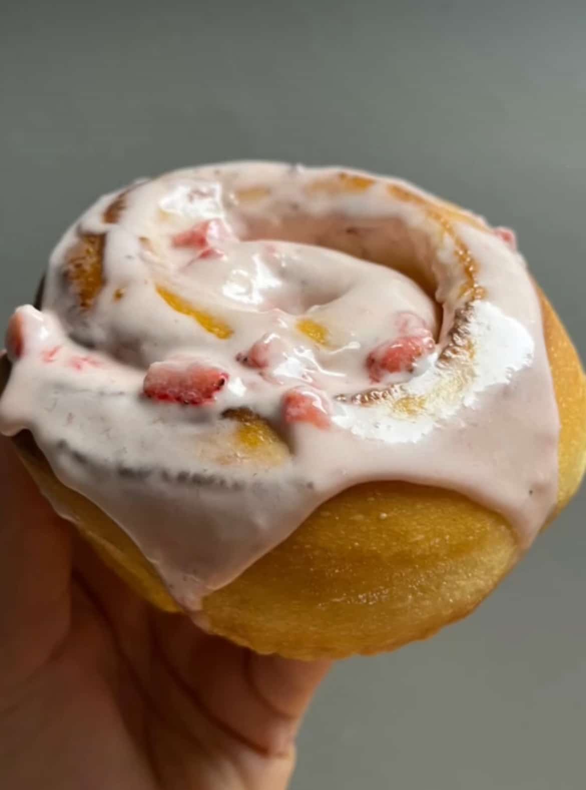 Strawberry sweet roll with pink icing and diced strawberries, fresh baked sourdough dessert.