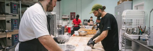 Bakers preparing sourdough bread in a commercial kitchen.
